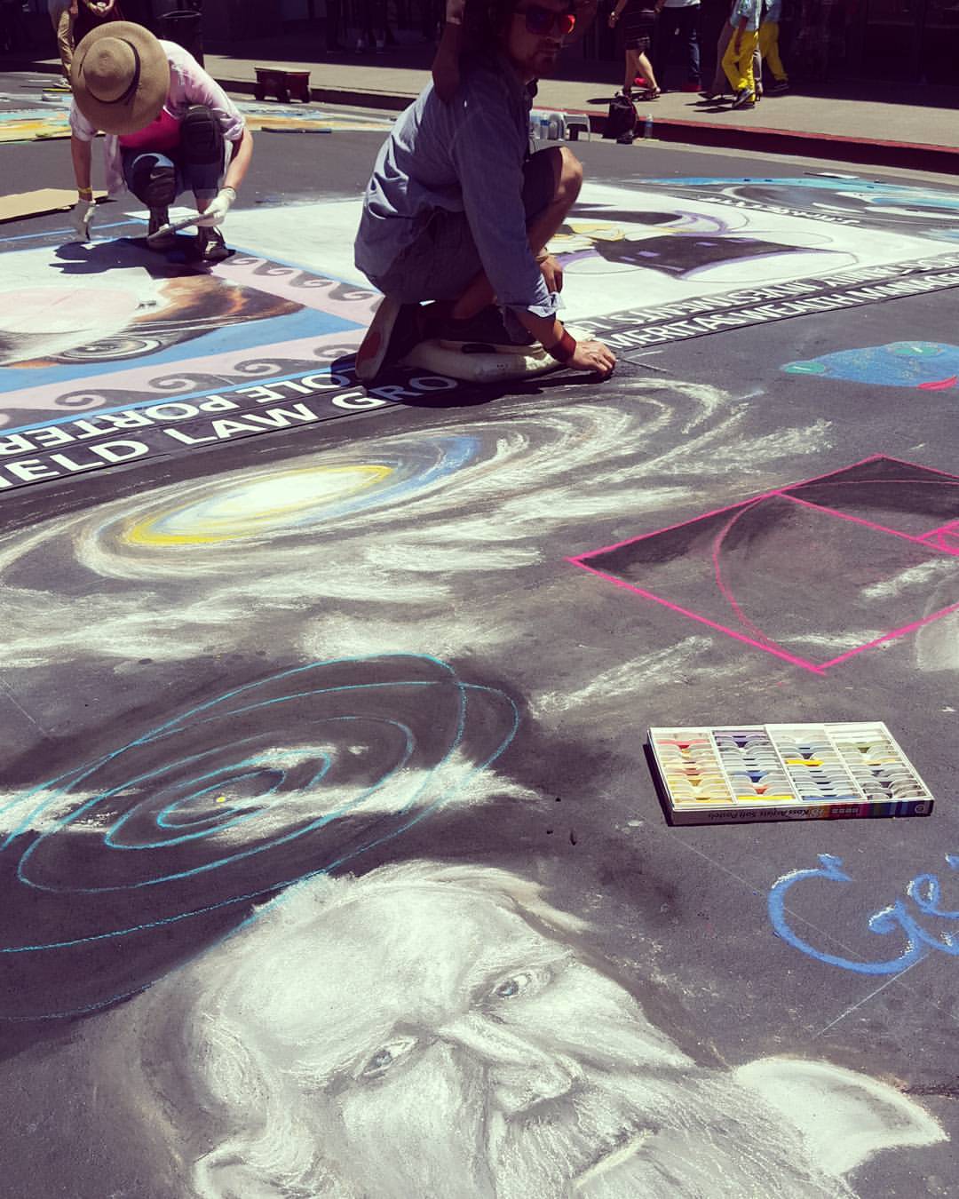 Artist in process of creating street painting
